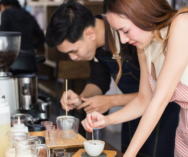 Young Asian people who dream of having a coffee shop is practicing to make coffee in a vocational training school.